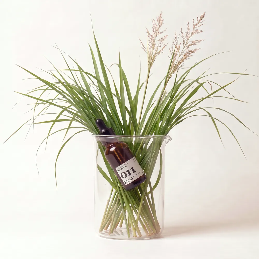 Tinh dầu Cỏ Gừng – Ginger Grass · chai tinh dầu trong ly nguyên liệu | Lê Mai