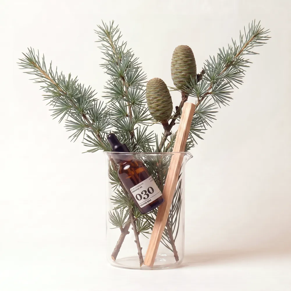 Tinh dầu Hoàng Đàn – Cedarwood · chai tinh dầu trong ly nguyên liệu | Lê Mai
