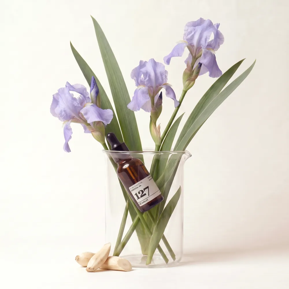 Orris Root Essential Oil · bottle in a glass of raw ingredients | Lê Mai