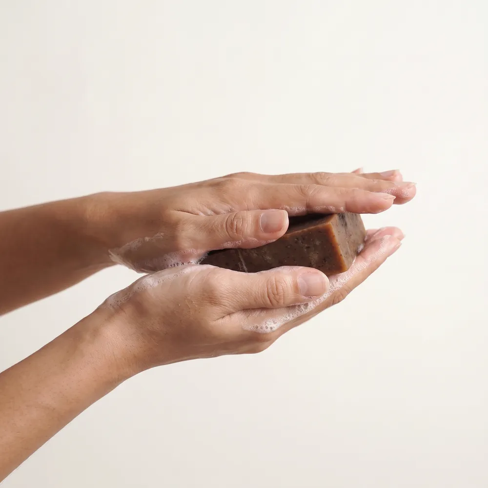 Mixed Herbs Tây Artisanal Soap No.098 · hand holding a lathered soap bar | Lê Mai