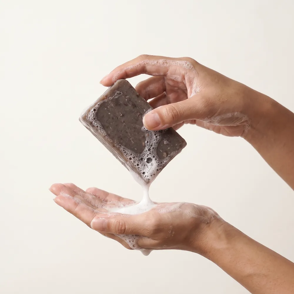 Tamanu – Neem Leaf Artisanal Soap No.096 · hand holding a lathering soap bar | Lê Mai