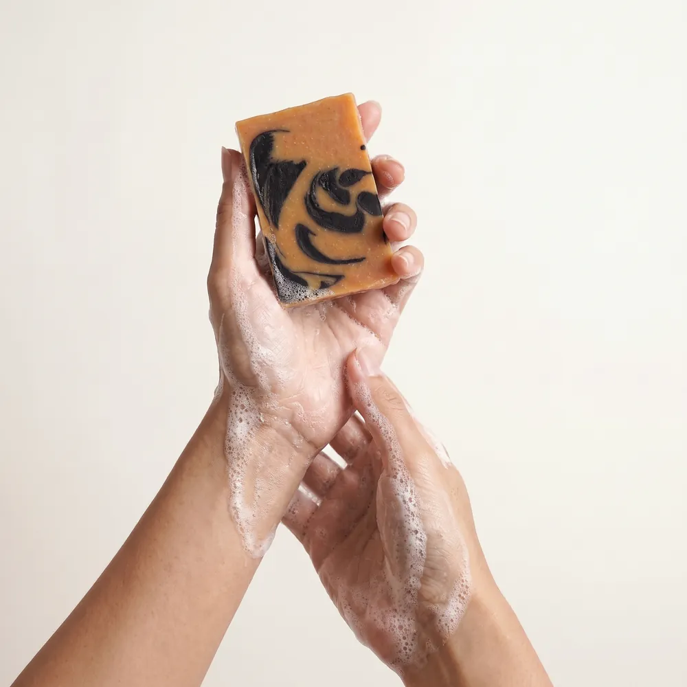 Lemongrass – Activated Charcoal Artisanal Soap · hand lathering the soap bar | Lê Mai